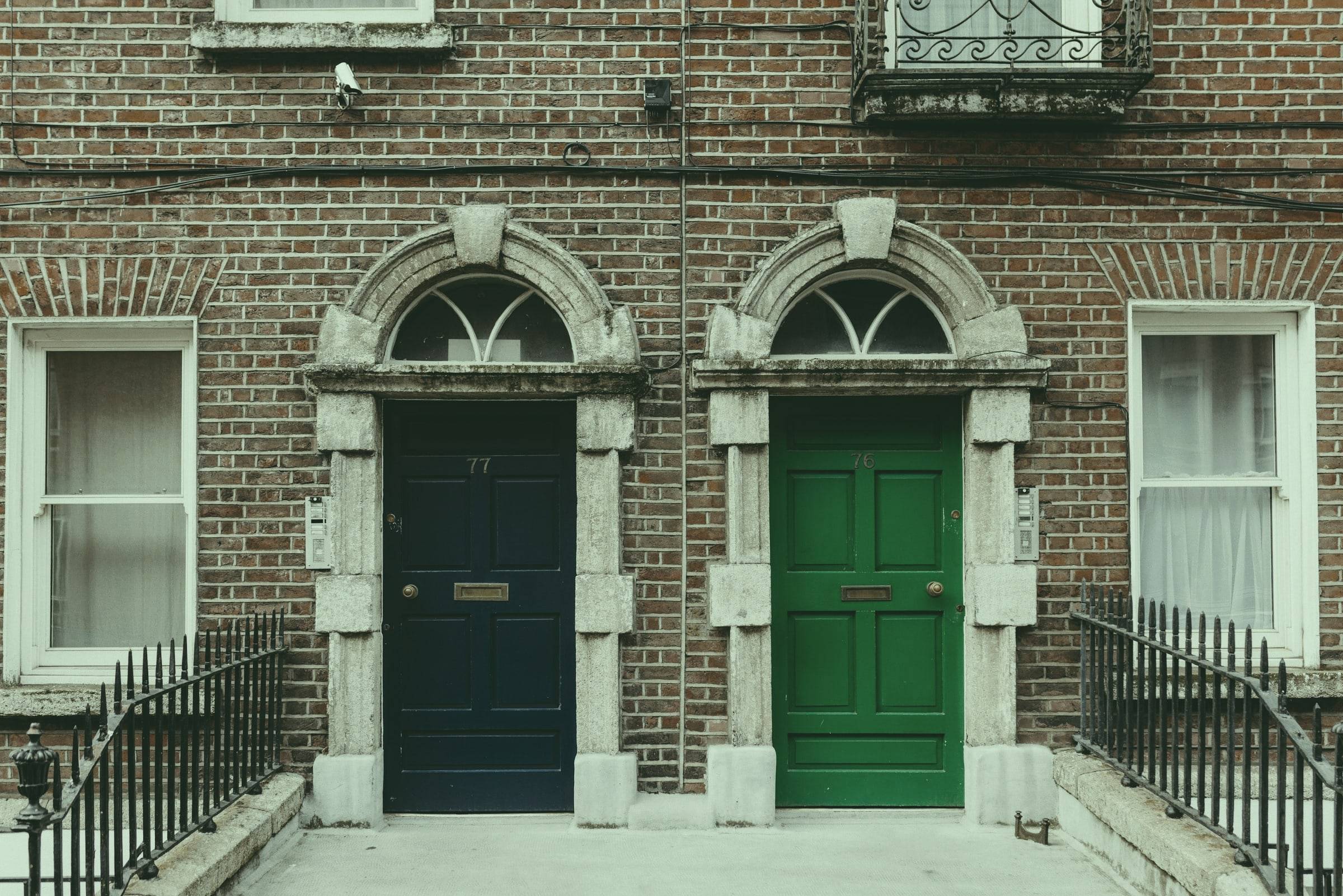 Navy and green Georgian doors on a red-brick Dublin terrace