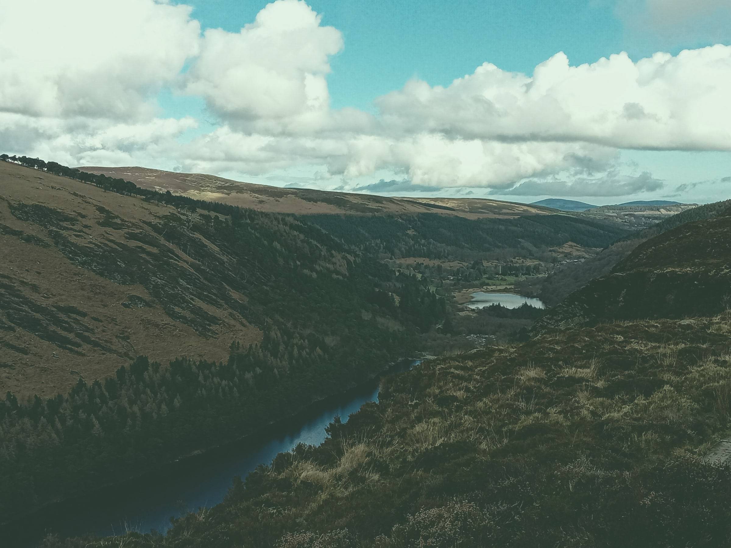 A wooded glen with a lake winding between steep hillsides