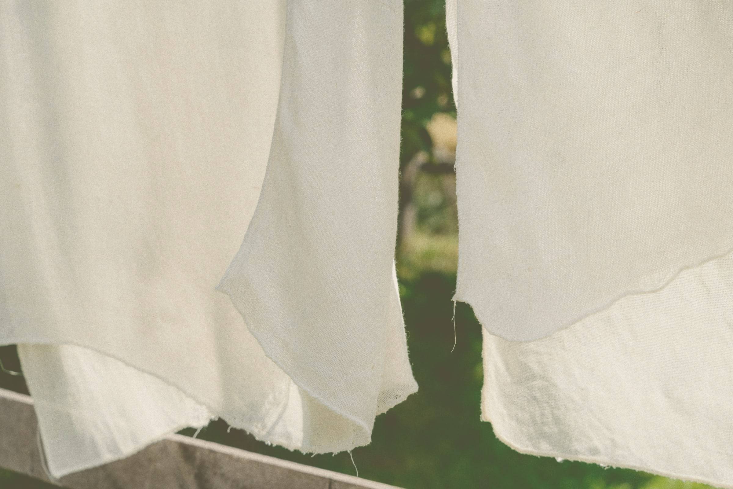 White linen sheets drying on a line in the sunshine